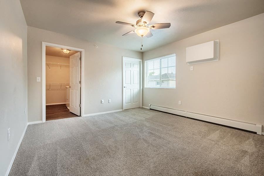 an empty living room with a ceiling fan