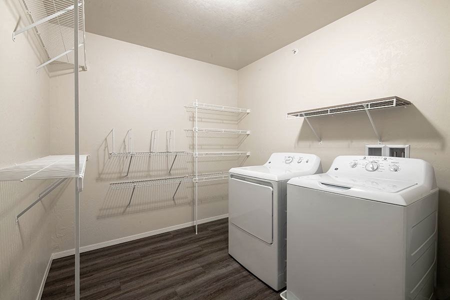 a white laundry room with two washes and a dryer