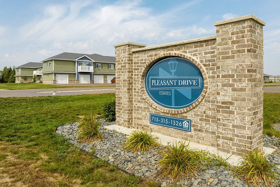 a brick building with a sign on it in front of some houses