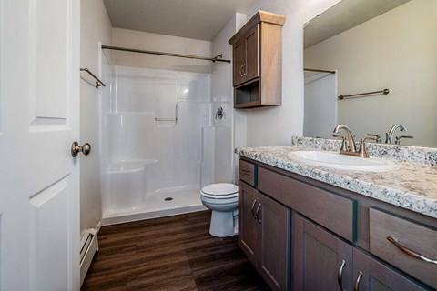 A bathroom with a toilet, sink, and shower.