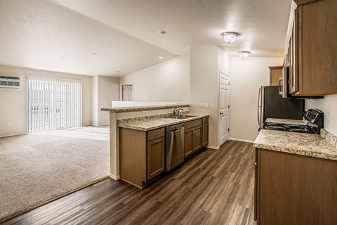 A kitchen with wooden cabinets and a granite countertop.