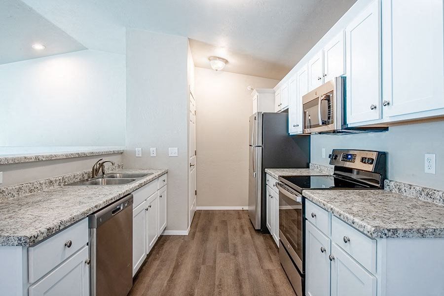 a kitchen with white cabinets and stainless steel appliances