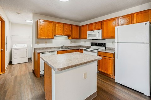 A kitchen with wooden cabinets and white appliances.