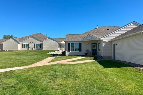 a row of houses with a yard and a sidewalk