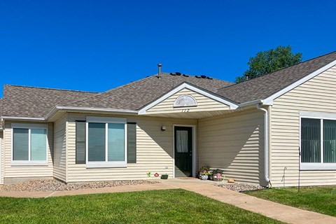a tan house with a sidewalk in front of it