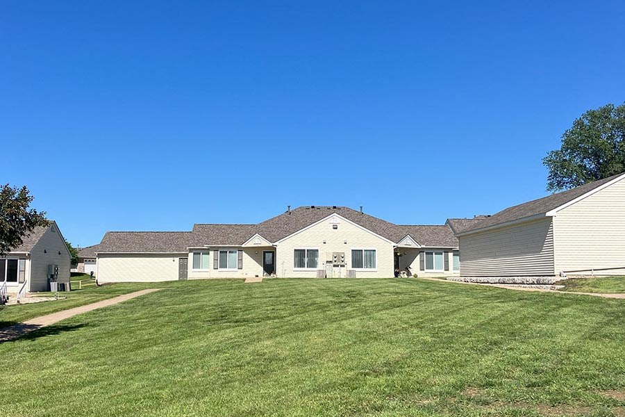 a group of houses on a large grassy yard