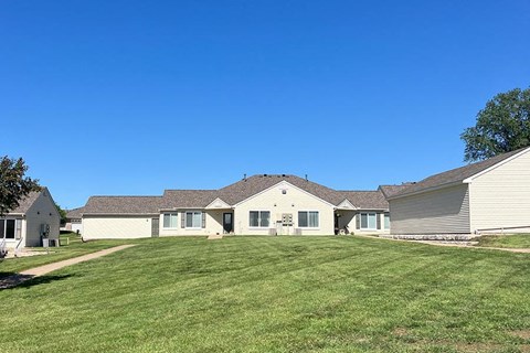 a group of houses on a large grassy yard