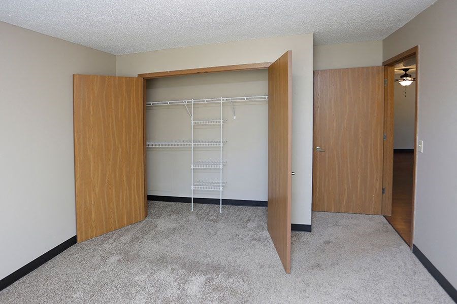 an empty bedroom with a closet with a ladder in it