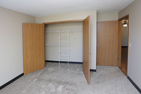 an empty bedroom with a closet with a ladder in it