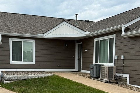 A house with a grey siding and a white window.