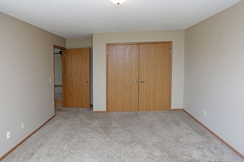 an empty living room with two wooden doors