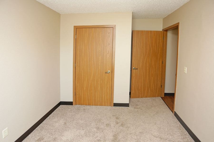 an empty room with a door and a closet