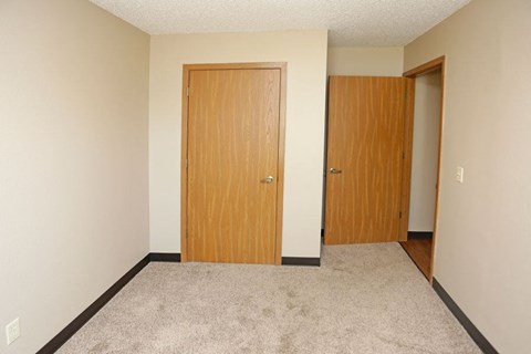 an empty room with a door and a closet