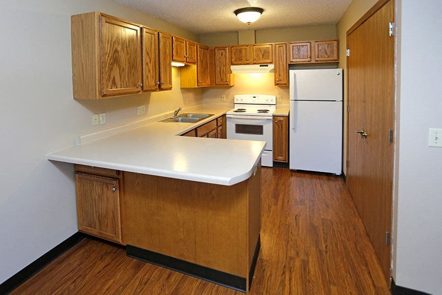 a kitchen with wooden cabinets and a white counter top