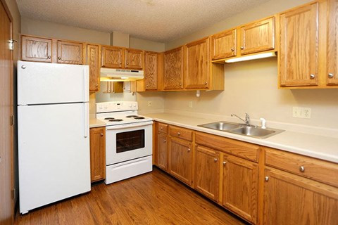 a kitchen with white appliances and wooden cabinets