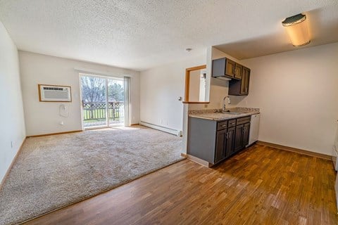 A room with a window and a wooden floor.
