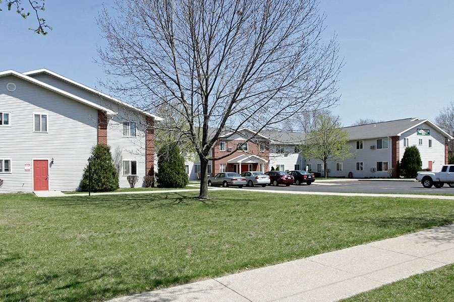 a group of houses with cars parked in the street