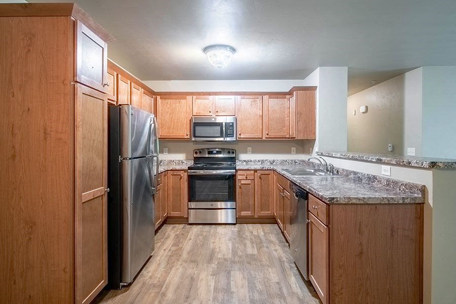 a kitchen with wooden cabinets and stainless steel appliances