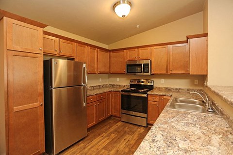 a kitchen with stainless steel appliances and wooden cabinets