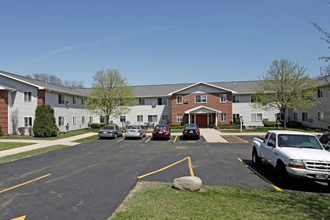 a parking lot with cars in front of an apartment building