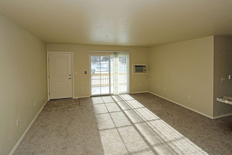 an empty living room with a door to a balcony