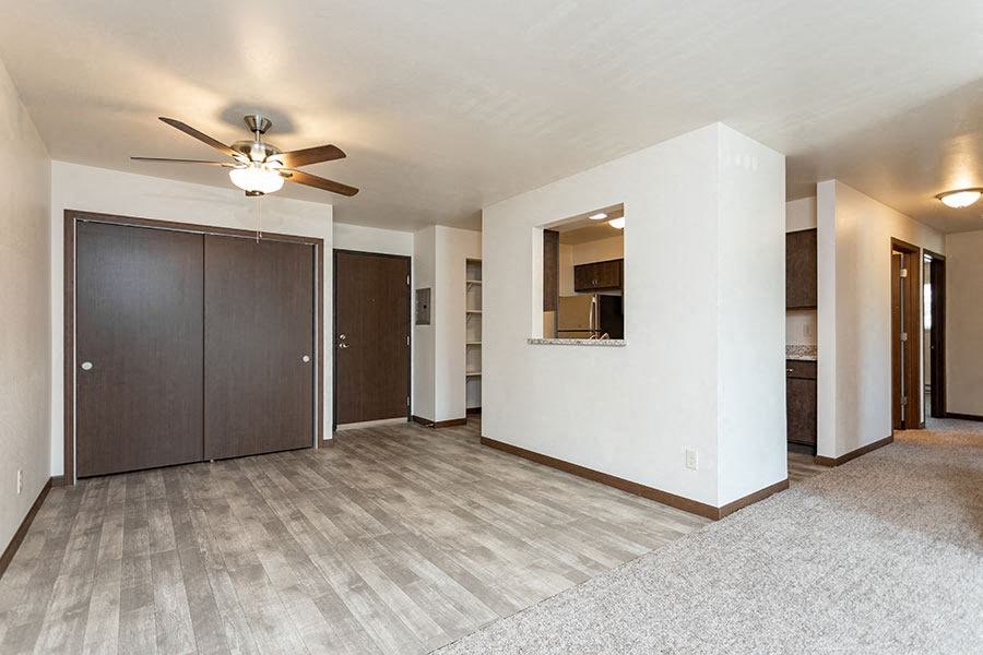 a empty living room with a ceiling fan