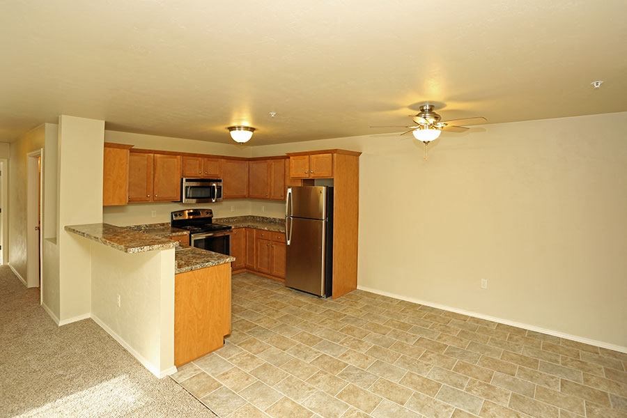 an empty kitchen with a stainless steel refrigerator