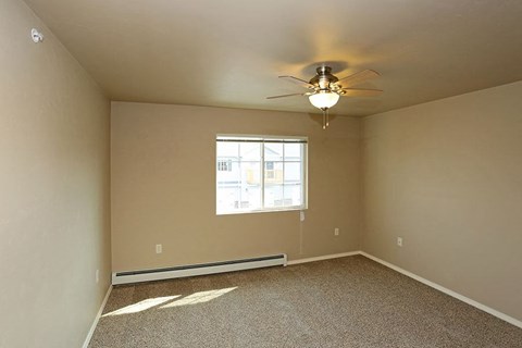 an empty room with a ceiling fan and a window