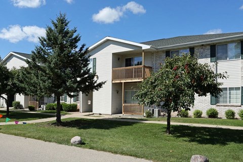 an apartment building with two trees in front of it