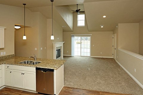 an empty kitchen and living room with a sink
