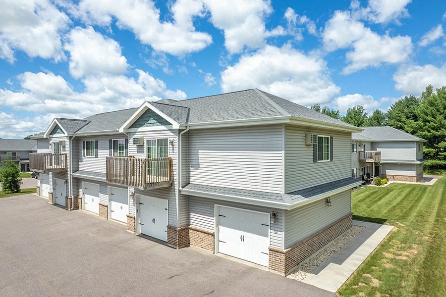 a row of houses with garages on the side of a street