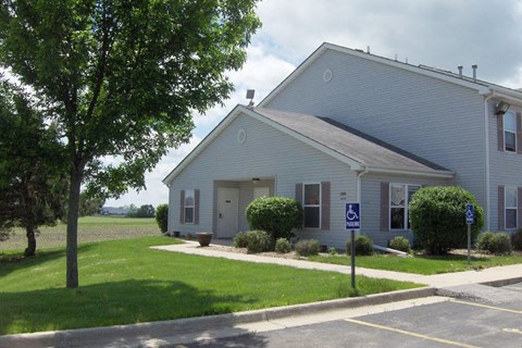 a white church building with a handicapped parking sign