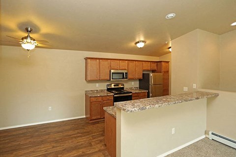 an empty kitchen with a granite counter top