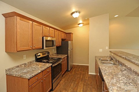 a kitchen with granite counter tops and stainless steel appliances