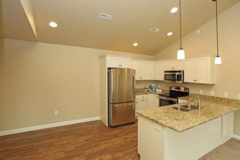 an empty kitchen with a stainless steel refrigerator