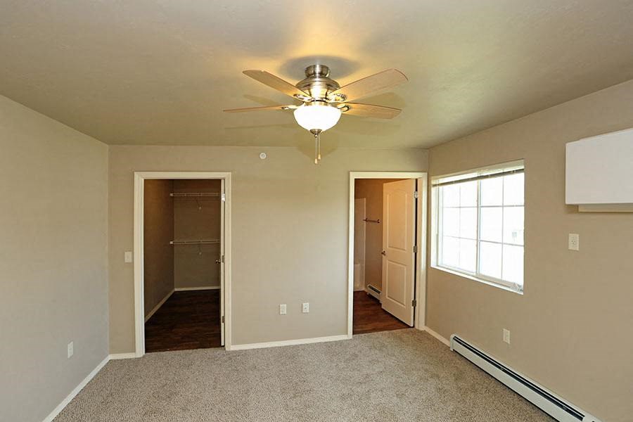 an empty living room with a ceiling fan