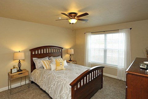a bedroom with a bed and a ceiling fan