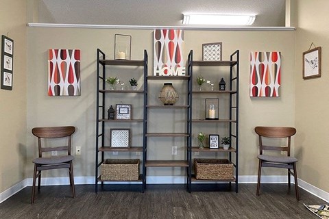 a living room with shelves and two chairs