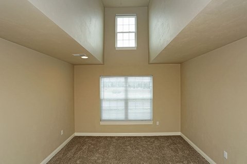 an empty room with a window and a carpet