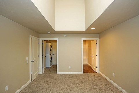 an empty room with a vaulted ceiling and a closet