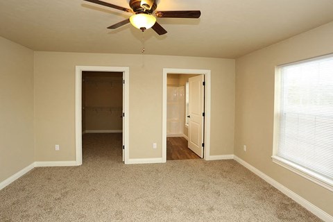 an empty room with a ceiling fan and a closet