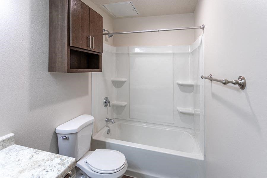 a white bathroom with a toilet and a bath tub