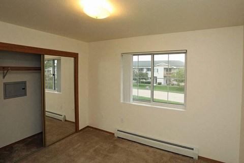 an empty living room with a window and a door