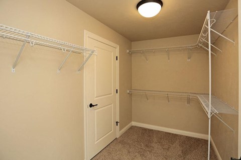 an empty closet with a white closet door and a white door to a closet