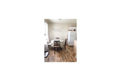 a living room with a dining room table and a refrigerator