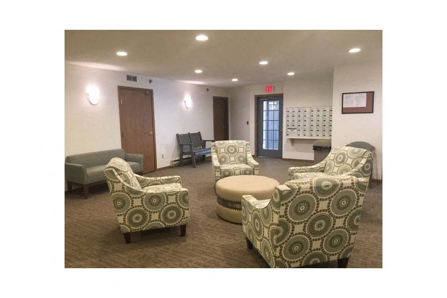 a lobby with chairs and a table and a door