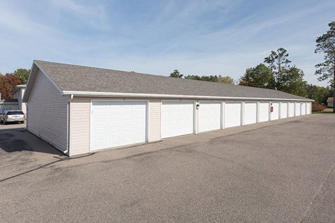 a white garage with white doors and a parking lot