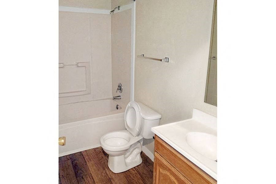 a bathroom with a toilet and a tub and a sink