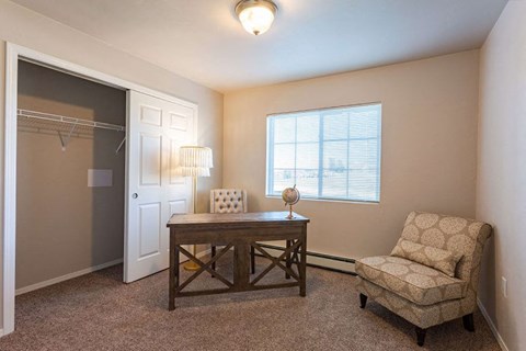a room with a desk and a chair and a closet
