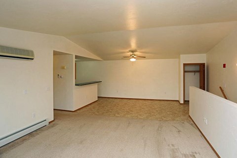 an empty living room with white walls and a ceiling fan